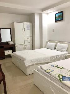 a bedroom with two beds and a television in it at Seven Stars Hotel in Ho Chi Minh City