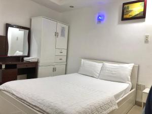 a bedroom with a bed with a dresser and a mirror at Seven Stars Hotel in Ho Chi Minh City