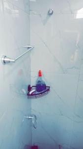 a bathroom with a shower with a bottle on a shelf at Chambre privée in Dakar