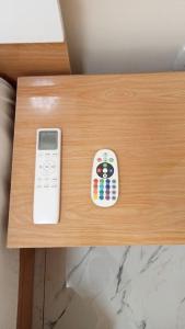 a remote control sitting on top of a wooden table at Chambre privée in Dakar
