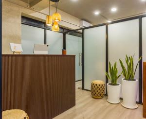 an office with a reception desk and potted plants at Etereo Stays, Luxury Premium Apartments, Arpora, Goa in Arpora