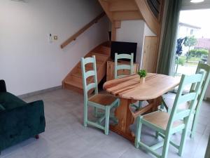 een eetkamer met een houten tafel en stoelen bij Gîtes de l'Orée du Bois in Boussières