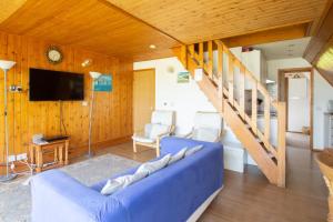 een woonkamer met een blauwe bank en een trap bij Chalet Seventyfour in Deal