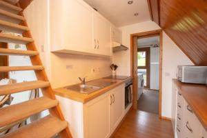 een keuken met een spoelbak en een trap in een klein huis bij Chalet Seventyfour in Deal +6 foto's