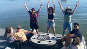 eine Gruppe von Menschen, die auf einem Boot auf dem Wasser sitzen in der Unterkunft Wow Houseboats Pty Ltd in White Sands