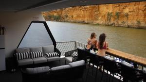 two women sitting on a boat in the water at Wow Houseboats Pty Ltd in White Sands