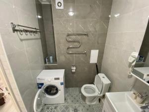 a small bathroom with a toilet and a sink at Astana Arena Apartment in Astana +15 photos