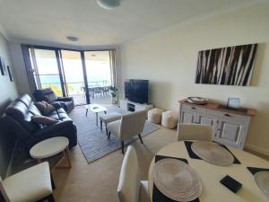 a living room with a couch and a table at Serenity by the Sea in Rockingham