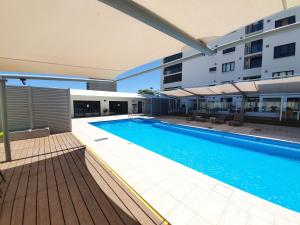 a swimming pool in front of a building at Serenity by the Sea in Rockingham