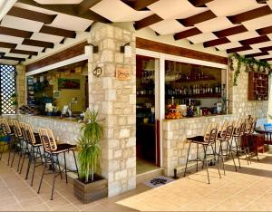 um restaurante com um bar com bancos em Socrates Studios em Tigaki