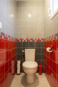 łazienka z toaletą i czerwonymi kafelkami w obiekcie Gîtes de l'Orée du Bois w mieście Boussières