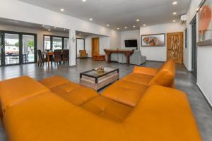 um sofá laranja numa sala de estar com uma mesa em 5 bedroom Villa Nune soul beach festival special em Paradera
