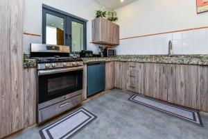 uma grande cozinha com armários de madeira e um fogão em 5 bedroom Villa Nune soul beach festival special em Paradera