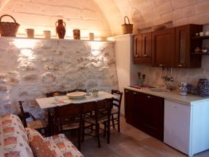 a kitchen with a table and some chairs in a room at Trullo Messapico in Ceglie Messapica