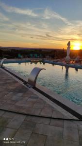 una piscina con un tramonto sullo sfondo di Complex Turistic Dávid a Boghiş