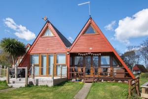 a home with a large red roof at Chalet Eightyone in Deal