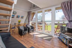 a living room with a view of the ocean at Chalet Eightyone in Deal