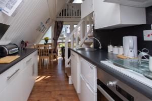 a kitchen with white cabinets and a black counter top at Chalet Eightyone in Deal +17 photos