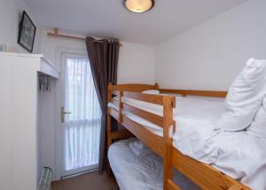 a bedroom with two bunk beds and a window at Chalet Eightyone in Deal