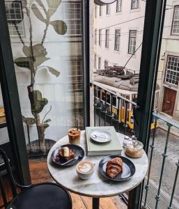 una mesa con platos de repostería y una ventana con tranvía en ToorakwhiteHouse3GrandKingBedrooms1BigGarden, en Melbourne