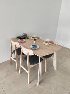 una mesa de madera con sillas y platos de comida. en Tropicana Golf view 7pax -1 Utama - Ikea -The Curve, en Petaling Jaya