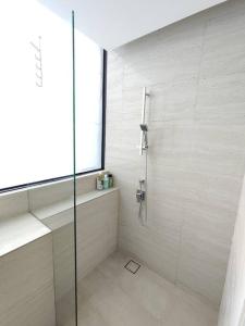 een badkamer met een douche en een glazen deur bij Tropicana Golf view 7pax -1 Utama - Ikea -The Curve in Petaling Jaya