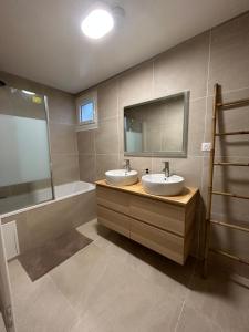 a bathroom with two sinks and a tub and a mirror at Appartement Bezons - La Défense in Bezons