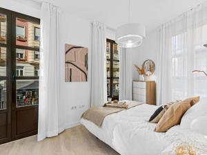 a white bedroom with a large bed and a window at Elegant and Central Location in Granada
