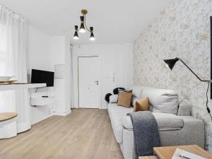 a white living room with a couch and a tv at Elegant and Central Location in Granada