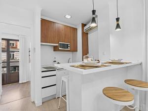 格拉納達的住宿－Elegant and Central Location，厨房配有白色的台面和木制橱柜
