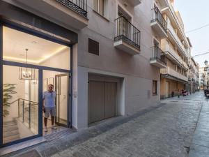 a man standing in a window of a building at Central Stylish and Elegant 1 & 2 BR apartments I in Granada