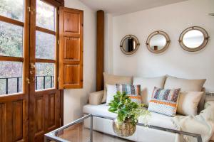 a living room with a couch and mirrors on the wall at CMH Alhambra Dreams - Luxury & Romantic Hideaway in Granada