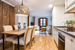 グラナダにあるCMH Alhambra Dreams - Luxury & Romantic Hideawayのキッチン、ダイニングルーム(木製のテーブルと椅子付)
