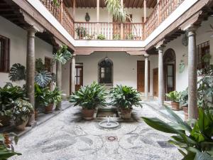 einen Innenhof mit Topfpflanzen in einem Gebäude in der Unterkunft Chezmoihomes Alhambra Penthouse in Granada
