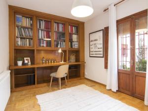 ein Heimbüro mit einem Schreibtisch und Bücherregalen in der Unterkunft Chezmoihomes Alhambra Penthouse in Granada