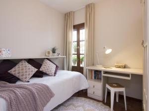 Chezmoihomes Alhambra Penthouse في غرناطة: غرفة نوم بسرير ومكتب ونافذة