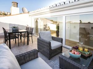 eine Terrasse mit einem Tisch und Stühlen sowie ein Esszimmer in der Unterkunft Chezmoihomes Premium Loft private terrace in Granada