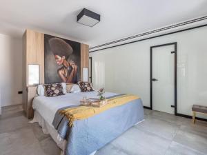 a bedroom with a large bed with a painting on the wall at Luxury Alhambra Penthouse Collection in Granada