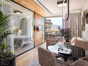 a living room with a table and chairs and a bedroom at Luxury Alhambra Penthouse Collection in Granada