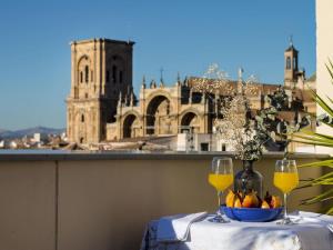 a table with two wine glasses and a bowl of fruit at Chezmoihomes Luxury Penthouse in Granada