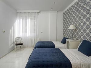 a hotel room with two beds and a chair at Chezmoihomes La Belle Epoque oversized in the very heart of Granada in Granada