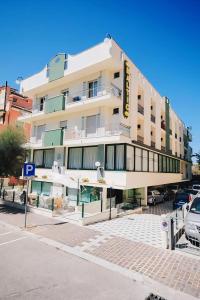 a building on a street with a parking lot at Hotel Baltic in Misano Adriatico