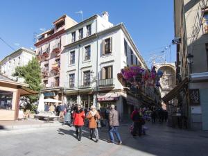 a group of people walking down a city street at Chezmoihomes Cathedral Apartment in Granada