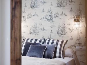a bedroom with a bed with a wallpaper with ships at Chezmoihomes Cathedral Apartment in Granada