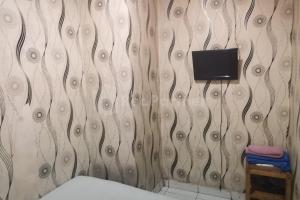 a bathroom with a tv on a wall at Tangki Residence 1 RedPartner in Jakarta +9 photos