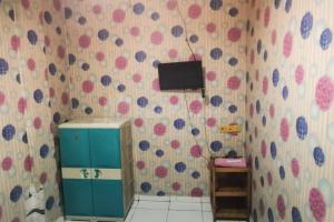 a bathroom with a blue cabinet and a tv on the wall at Tangki Residence 1 RedPartner in Jakarta