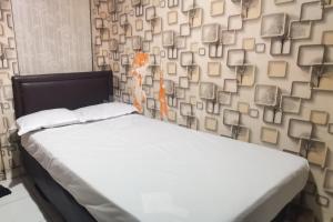 a bed in a room with a wall of books at Tangki Residence 1 RedPartner in Jakarta