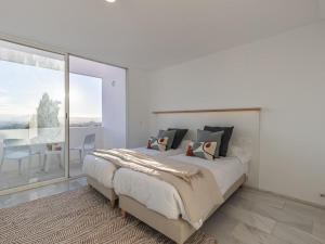 um quarto branco com uma cama grande e uma varanda em My White Wall Realejo em Granada