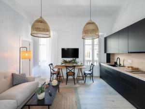 a kitchen and living room with a couch and a table at Bright and Elegant Gran Via apartments in Granada