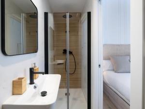 a bathroom with a sink and a shower and a bed at Bright and Elegant Gran Via apartments in Granada